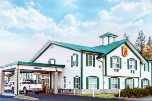 ein Gebäude mit einem LKW, der davor parkt in der Unterkunft Super 8 by Wyndham 100 Mile House in One Hundred Mile House