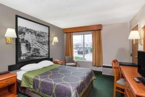 ein kleines Hotelzimmer mit einem Bett und einem Fenster in der Unterkunft Super 8 by Wyndham Athens in Athens