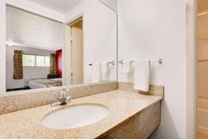 a bathroom with a sink and a mirror at Ramada by Wyndham Cleveland Airport West in Fairview Park