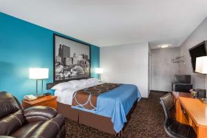 a hotel room with a bed and a couch at Super 8 by Wyndham Belleville St. Louis Area in Belleville