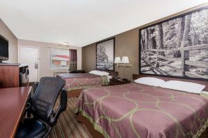 a hotel room with two beds and a desk at Super 8 by Wyndham Chattanooga Ooltewah in Ooltewah