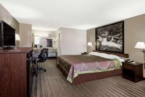 a hotel room with a bed and a desk at Super 8 by Wyndham Chattanooga Ooltewah in Ooltewah