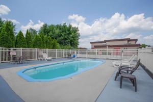 a large swimming pool with chairs and a fence at Super 8 by Wyndham Carlisle North in Carlisle