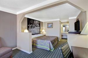 a hotel room with a bed and a television at Super 8 by Wyndham Knoxville East in Knoxville