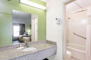 a bathroom with a sink, toilet and mirror at Super 8 by Wyndham Tifton in Tifton