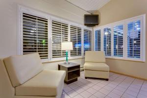 a living room with two chairs and a lamp and windows at Super 8 by Wyndham Alturas in Alturas