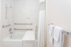 a white bathroom with a tub and a shower at Super 8 by Wyndham Tifton in Tifton