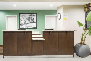 a waiting room with a counter and a clock at Super 8 by Wyndham Valdosta GA I-75 in Valdosta