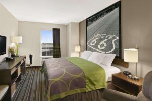 a hotel room with a bed and a flat screen tv at Super 8 by Wyndham Stafford/Springfield Area in Strafford