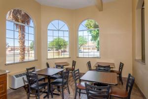 un comedor con mesas, sillas y ventanas en Super 8 by Wyndham Hurricane Zion National Park en Hurricane