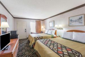 a hotel room with two beds and a flat screen tv at Super 8 by Wyndham Ashburn in Ashburn