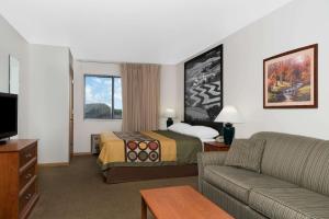 a hotel room with a bed and a couch at Super 8 by Wyndham Sparta in Sparta