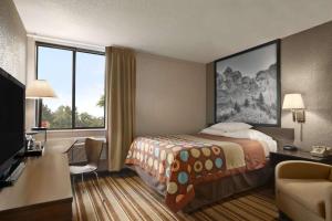 ein Hotelzimmer mit einem Bett und einem Schreibtisch in der Unterkunft Super 8 by Wyndham Redfield in Redfield