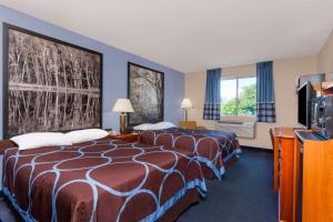 a hotel room with two beds and a tv at Super 8 by Wyndham Adrian in Adrian