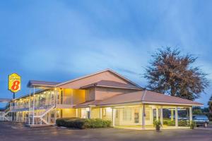 Un edificio con un estacionamiento enfrente. en Super 8 by Wyndham Madison, en Madison