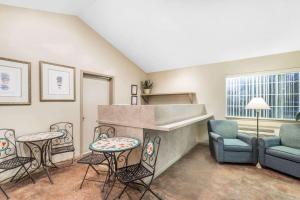 sala de estar con chimenea, sillas y mesas en Super 8 by Wyndham Madison, en Madison
