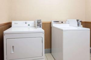 two washing machines and a washer and dryer in a room at Super 8 by Wyndham Carrollton in Carrollton