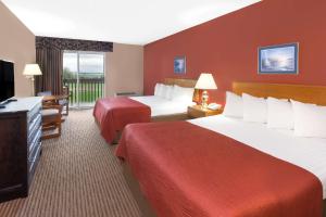 a hotel room with two beds and a television at Super 8 by Wyndham St. Ignace in Saint Ignace