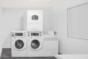 a laundry room with two washing machines and a window at Super 8 by Wyndham Barstow in Barstow
