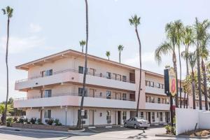 a large building with palm trees and palm trees at Super 8 by Wyndham Santa Barbara/Goleta in Santa Barbara