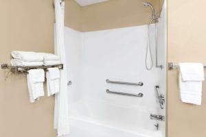 a white towel hanging on a white wall next to a shower at Super 8 by Wyndham St. Ignace in Saint Ignace