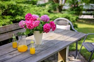 uma mesa de madeira com flores e duas garrafas de sumo de laranja em Landhaus Danita em Bodensdorf