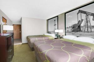 a hotel room with two beds with a painting on the wall at Super 8 by Wyndham Bedford DFW Airport West in Bedford
