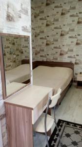 アナパにあるLivadiya Guest Houseの鏡、デスク、ベッド1台が備わるベッドルーム1室が備わります。
