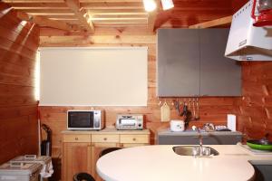 a kitchen with wooden walls and a white counter top at Stay in Toya in Lake Toya