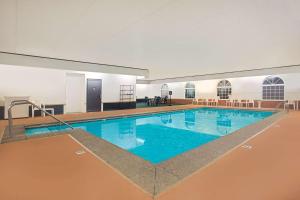 - une grande piscine d'eau bleue dans un bâtiment dans l'établissement Super 8 by Wyndham New Hampton, à New Hampton