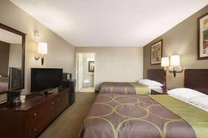 a hotel room with two beds and a flat screen tv at Super 8 by Wyndham Ormond Beach in Ormond Beach