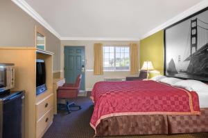 ein Hotelzimmer mit einem Bett und einem TV in der Unterkunft Super 8 by Wyndham Hayward Downtown in Castro Valley