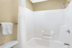 a white bathroom with a tub and a shower at Super 8 by Wyndham Olney in Olney