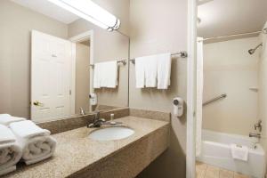 a bathroom with a sink and a mirror at Super 8 by Wyndham Ormond Beach in Ormond Beach +18 photos