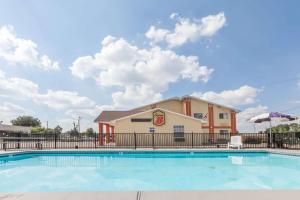 a swimming pool with a building in the background at Super 8 by Wyndham Chickasha in Chickasha