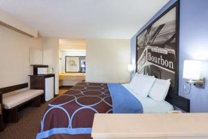 a large hotel room with a bed and a kitchen at Super 8 by Wyndham Hammond in Hammond