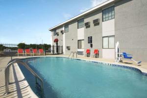 a swimming pool in front of a building at Super 8 by Wyndham Ardmore in Ardmore