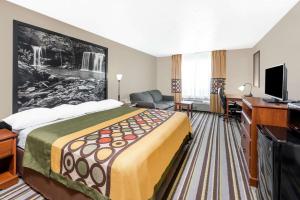 a hotel room with a large bed and a desk at Super 8 by Wyndham Bolivar in Bolivar