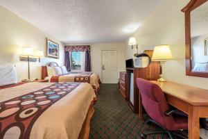 a hotel room with two beds and a desk at Super 8 by Wyndham Eastland in Eastland