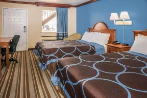 a hotel room with two beds and a desk at Super 8 by Wyndham San Marcos in San Marcos