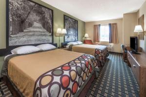 a hotel room with two beds and a television at Super 8 by Wyndham Greenville in Greenville
