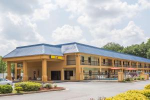 a large yellow building with a blue roof at Super 8 by Wyndham Norcross/I-85 Atlanta in Norcross