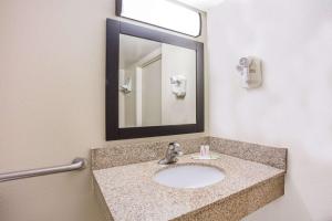 a bathroom with a sink and a mirror at Super 8 by Wyndham Camp Springs/Andrews AFB DC Area in Camp Springs