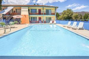 a swimming pool with chairs and a house in the background at Super 8 by Wyndham Yreka in Yreka