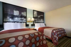 ein Hotelzimmer mit 2 Betten und 2 Lampen in der Unterkunft Super 8 by Wyndham Park City/North Wichita Area in Park City