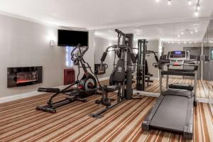 een fitnessruimte met loopbanden en een flatscreen-tv bij Super 8 by Wyndham Schenectady/Albany Area in Schenectady