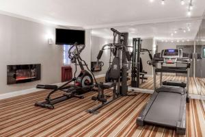 a gym with tread machines and a flat screen tv at Super 8 by Wyndham Schenectady/Albany Area in Schenectady
