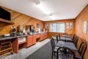 a kitchen with orange cabinets and a table and chairs at Super 8 by Wyndham Estherville in Estherville