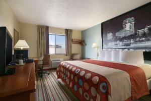 a hotel room with a large bed and a television at Super 8 by Wyndham Park City/North Wichita Area in Park City