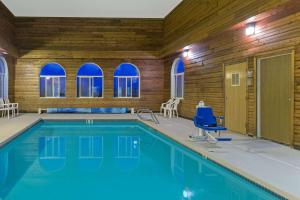 a pool with blue water in a room with windows at Super 8 by Wyndham Green River in Green River